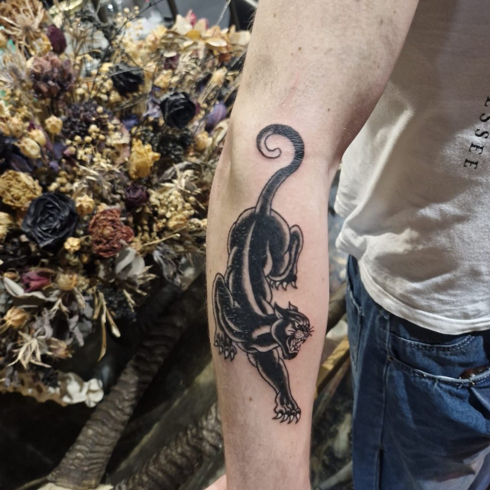 tattoo of a traditional panther on lower arm