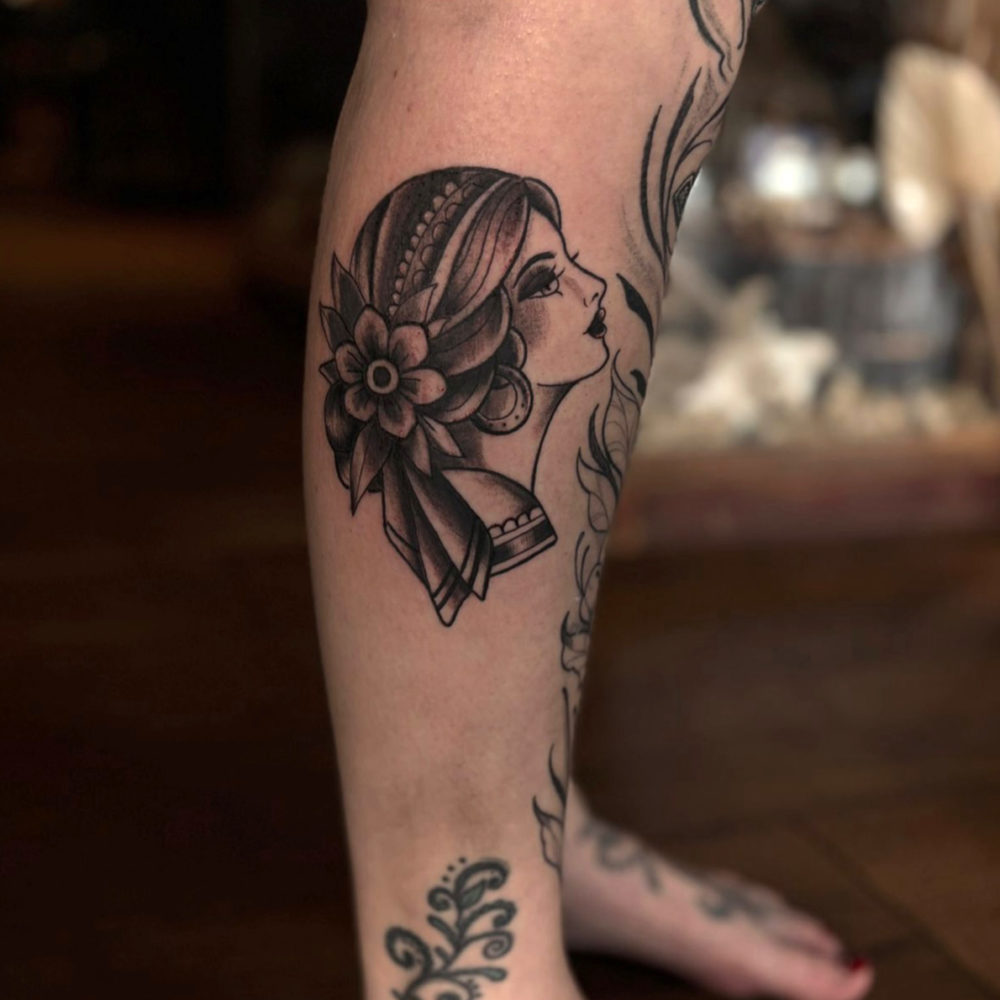 Liv-Valentine-LadyFace-Tattoo Photo shows a leg with a tattoo of a neo traditional lady face design