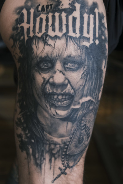 Image of a large black and grey thigh tattoo themed from the exorcist movie