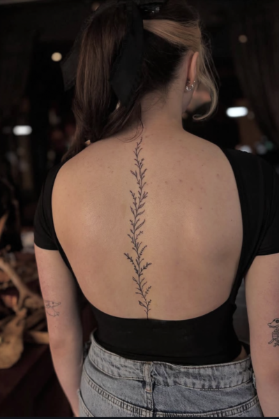 Image of a delicate floral tattoo down the spine