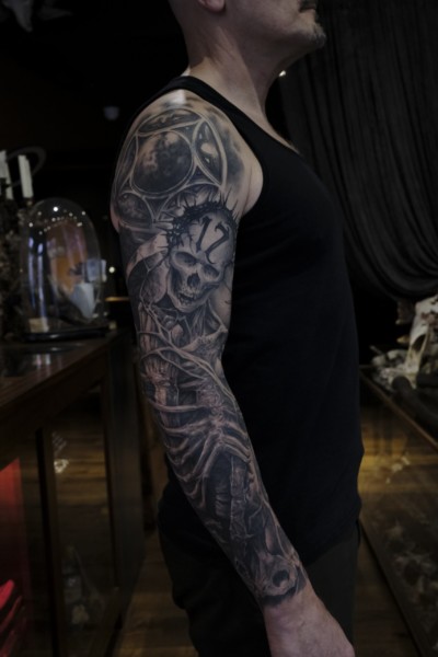 Black and grey tattoo sleeve featuring a custom skeleton and slayer themed artwork