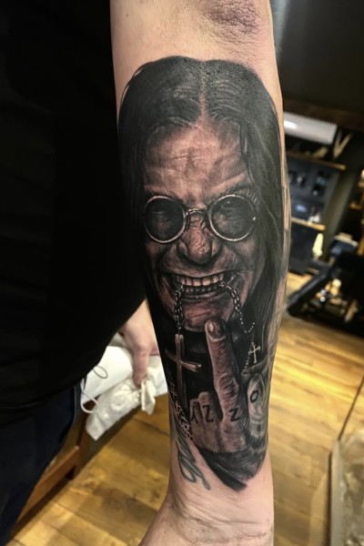 An image of an arm tattoo featuring a portrait of ozzy osbourne