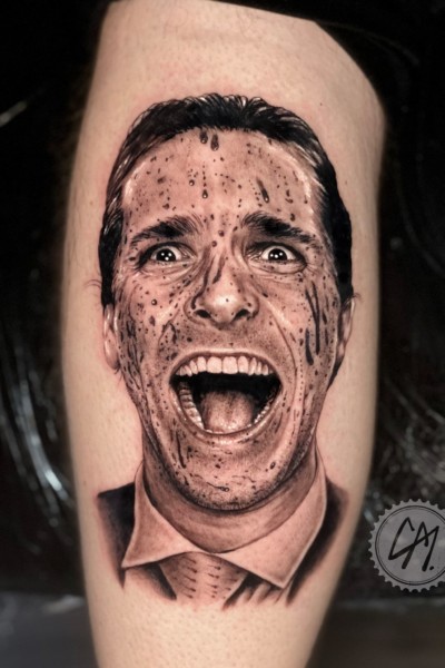 A tattoo of the famous face of christian bale in american psycho covered in blood