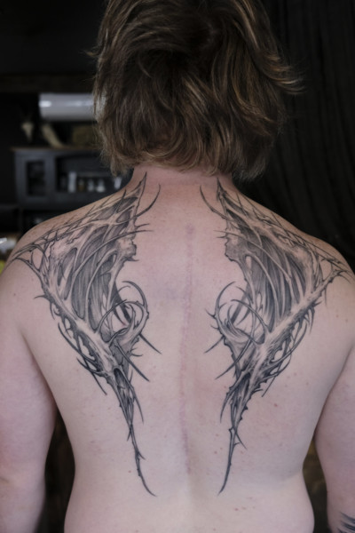 an image of a custom back tattoo that is in a blackwork organic bone and thorn design